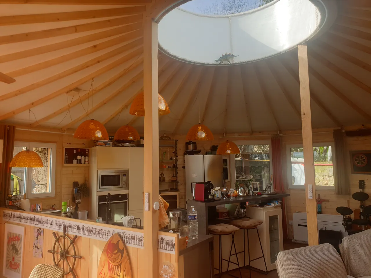 Cuisine d'une maison ronde en bois, sous le puits de lumière